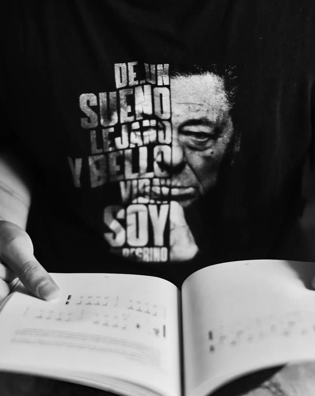 Un libro abierto en una página de partitura, sostenido con las dos manos.
